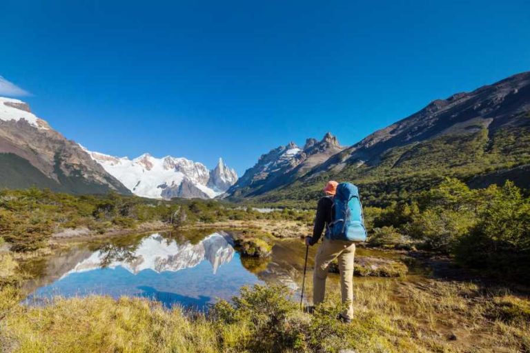 Gondwanaland: The epic history of the world, and our name 8 A hiker stands looking over a lake in the mountains of Patagonia. There are mountains surrounding the person and the blue sky reflects in the lake.