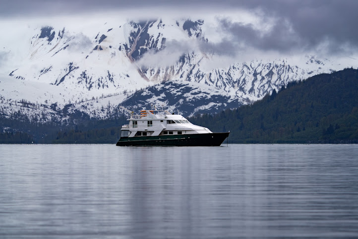 Alaska: Navigating the Inside Passage 5 A yacht sails through the Inside Passage of Alaska, flanked by snowy mountains